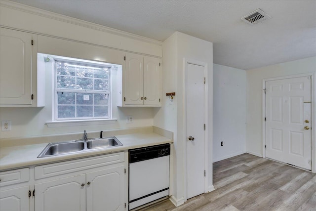 kitchen featuring white cabinets, light countertops, white dishwasher, and a sink