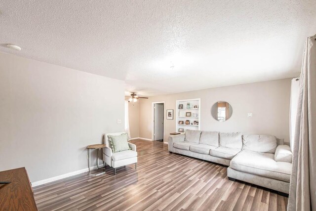 living room with wood finished floors, a textured ceiling, and a ceiling fan