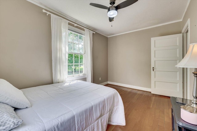 bedroom with ceiling fan, hardwood / wood-style flooring, and ornamental molding