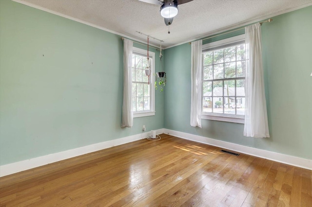 empty room featuring hardwood / wood-style floors, a textured ceiling, ceiling fan, and crown molding