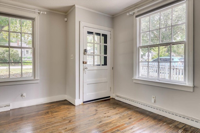 doorway to outside with hardwood / wood-style floors, baseboard heating, and ornamental molding