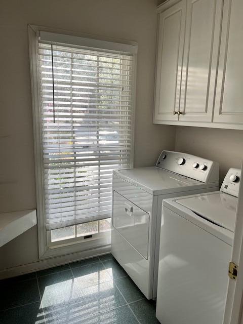 laundry room featuring cabinet space, washer and dryer, and granite finish floor