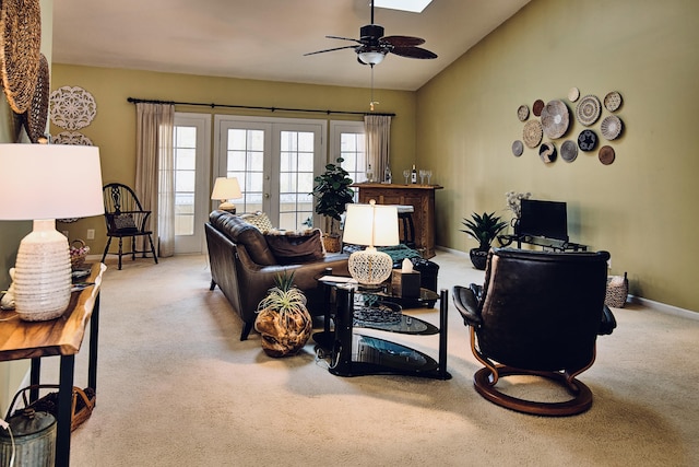 carpeted living room with a ceiling fan, lofted ceiling, french doors, and baseboards