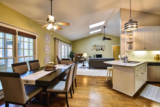 kitchen with a sink, open shelves, white cabinetry, stainless steel appliances, and a peninsula