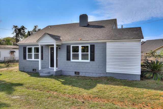 rear view of house featuring a lawn