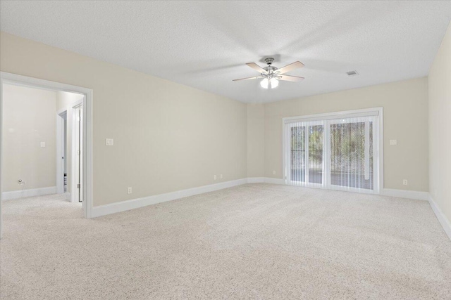 carpeted empty room featuring ceiling fan and a textured ceiling