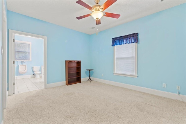 carpeted spare room featuring ceiling fan