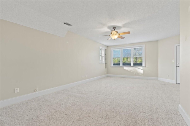 spare room with carpet, ceiling fan, and a textured ceiling