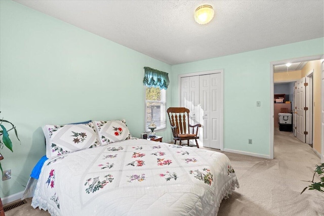 bedroom with a textured ceiling, light colored carpet, and a closet