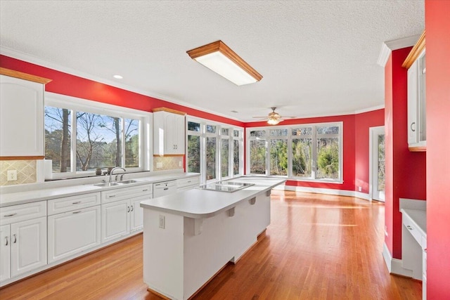 kitchen featuring decorative backsplash, white cabinetry, and a kitchen island