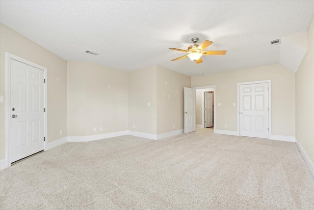 carpeted spare room featuring a textured ceiling and ceiling fan