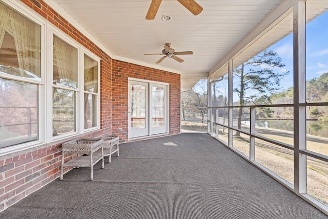 unfurnished sunroom featuring ceiling fan