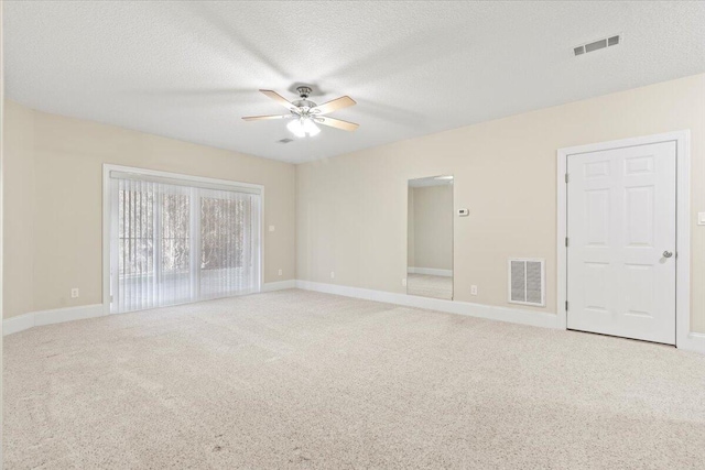 carpeted empty room with a textured ceiling and ceiling fan