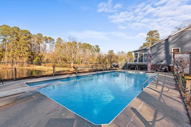 view of pool with a diving board and a patio