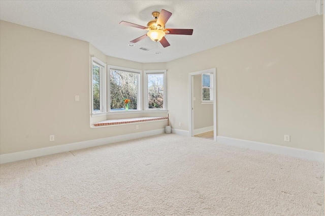 carpeted spare room with ceiling fan and a textured ceiling