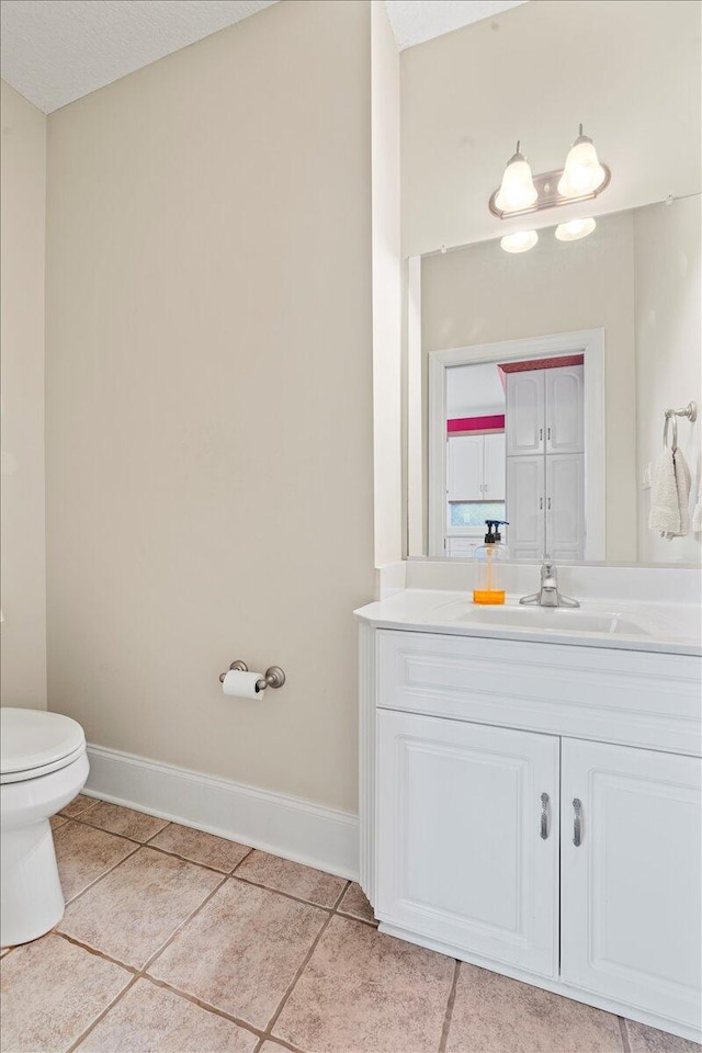 bathroom featuring tile patterned floors, vanity, and toilet