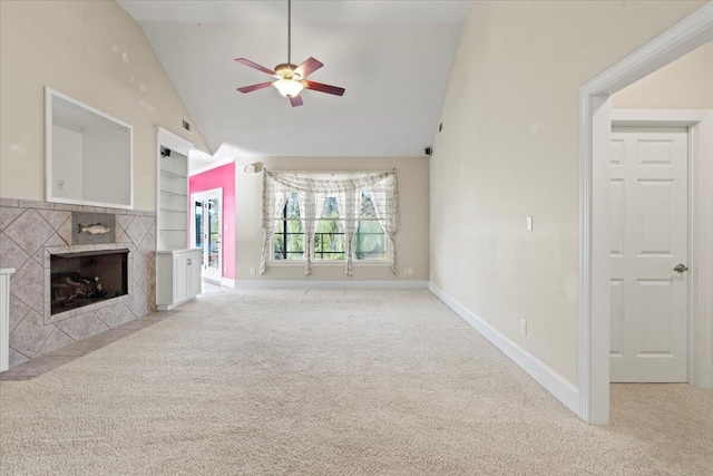 unfurnished living room featuring high vaulted ceiling, a tile fireplace, built in shelves, ceiling fan, and light colored carpet