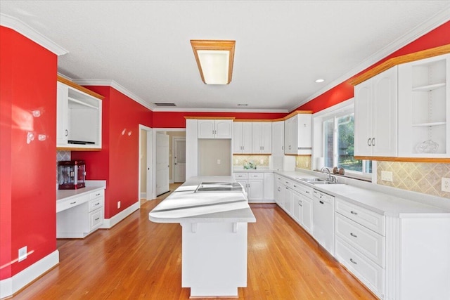 kitchen with tasteful backsplash, a center island, white cabinets, and light wood-type flooring