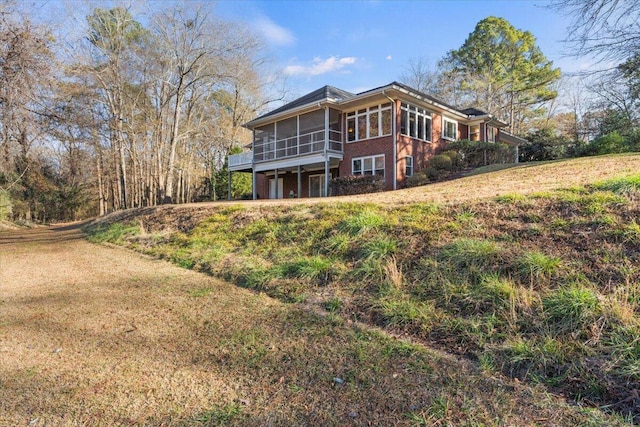 rear view of property featuring a sunroom and a yard