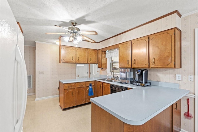 kitchen featuring kitchen peninsula, white refrigerator, ornamental molding, and sink