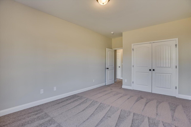 unfurnished bedroom with a closet and light colored carpet