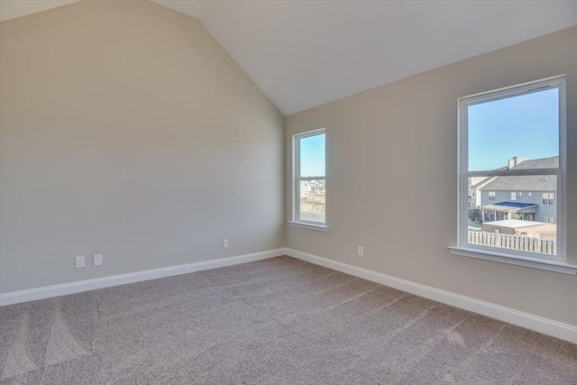 carpeted empty room featuring vaulted ceiling