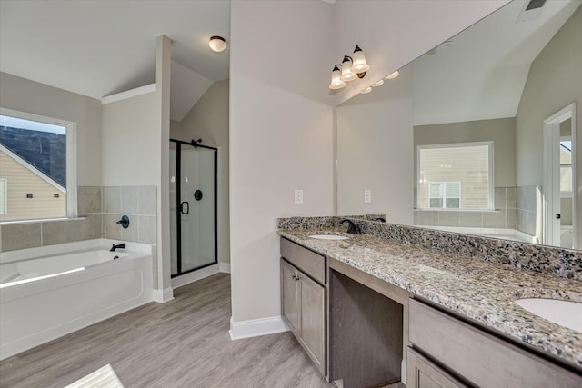 bathroom with separate shower and tub, vanity, wood-type flooring, and vaulted ceiling