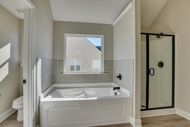 bathroom with hardwood / wood-style flooring, separate shower and tub, and toilet