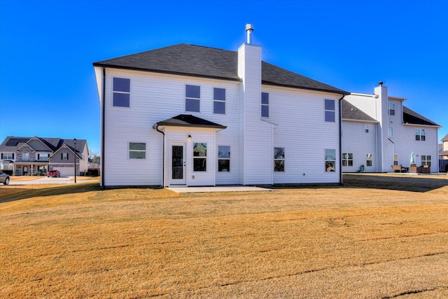 rear view of property featuring a lawn