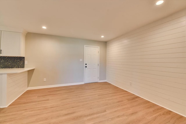 interior space with baseboards, recessed lighting, and light wood-style floors