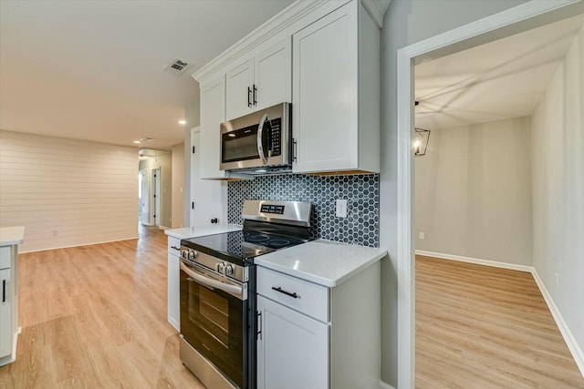 kitchen featuring visible vents, light countertops, appliances with stainless steel finishes, light wood finished floors, and tasteful backsplash