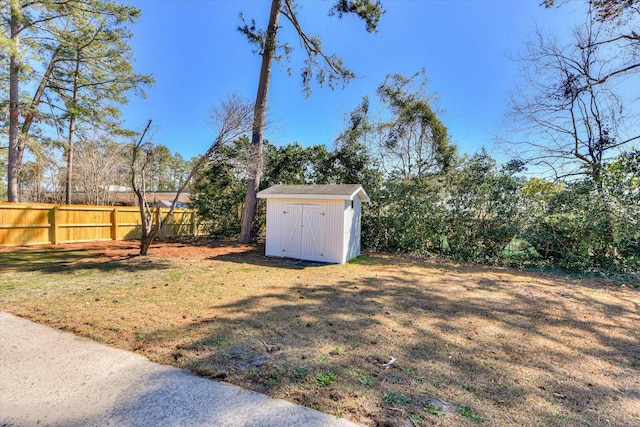 view of yard featuring a storage unit, an outdoor structure, and a fenced backyard