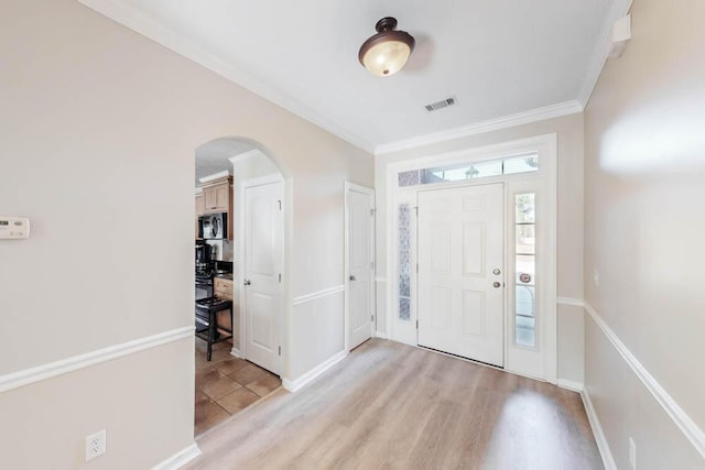 foyer featuring light hardwood / wood-style flooring and crown molding