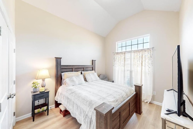 bedroom featuring vaulted ceiling and light wood-type flooring