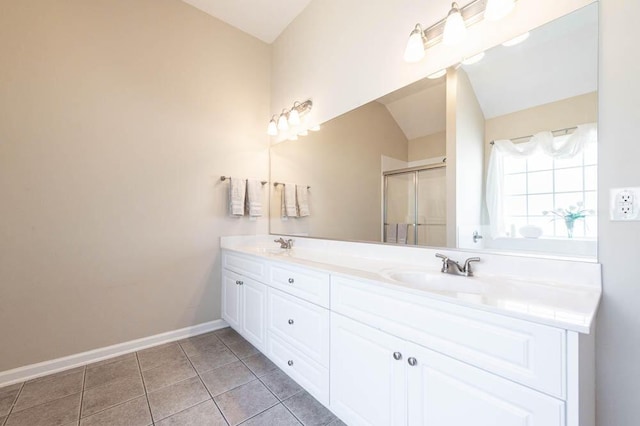 bathroom with tile patterned flooring, vanity, a shower with door, and vaulted ceiling