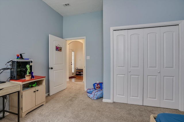 bedroom featuring light colored carpet and a closet