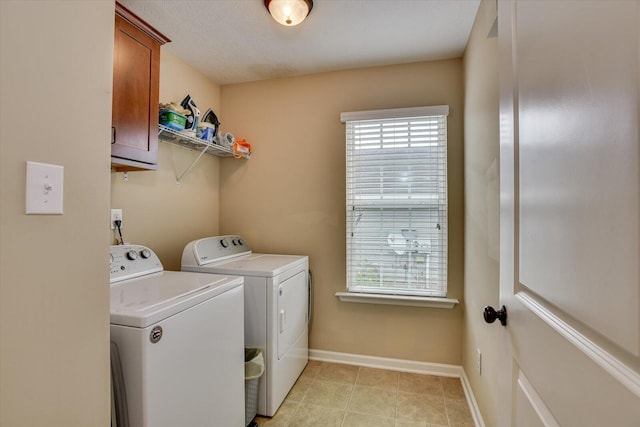 clothes washing area featuring cabinets and washer and dryer