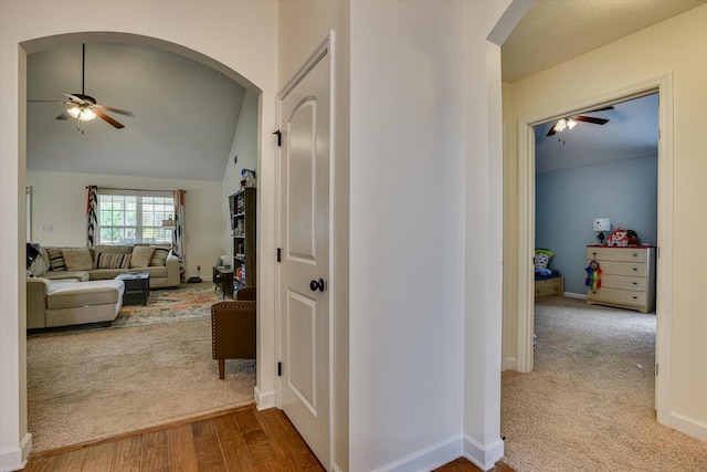 corridor featuring light colored carpet and lofted ceiling