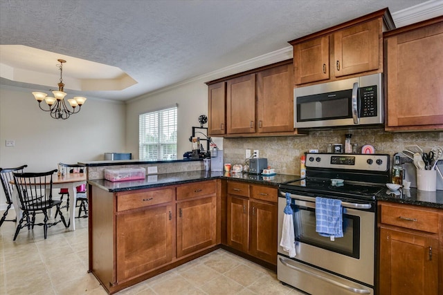 kitchen featuring a raised ceiling, kitchen peninsula, a chandelier, and appliances with stainless steel finishes