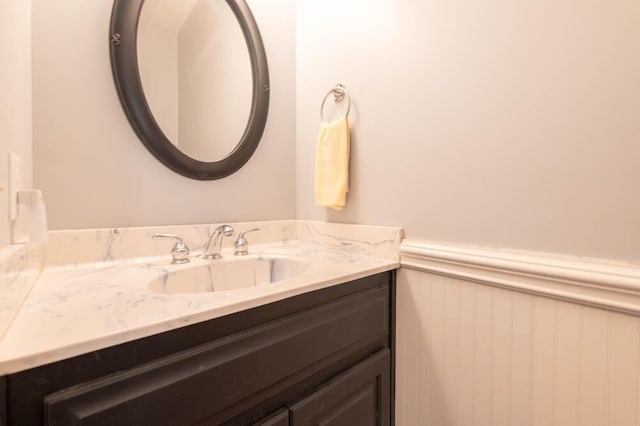 bathroom with a wainscoted wall and vanity