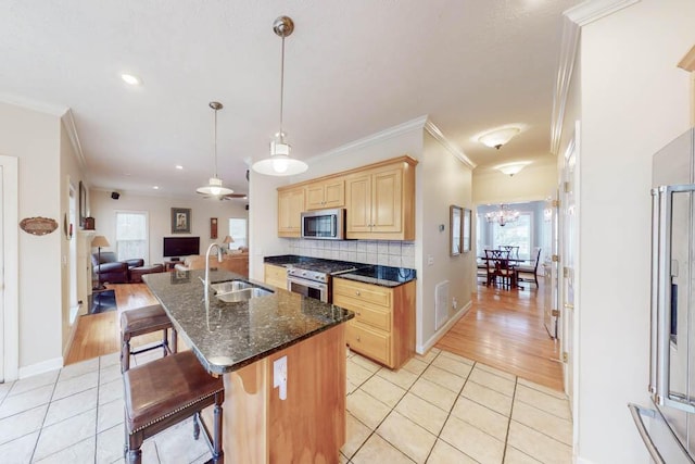 kitchen featuring light brown cabinetry, light tile patterned floors, appliances with stainless steel finishes, and a sink