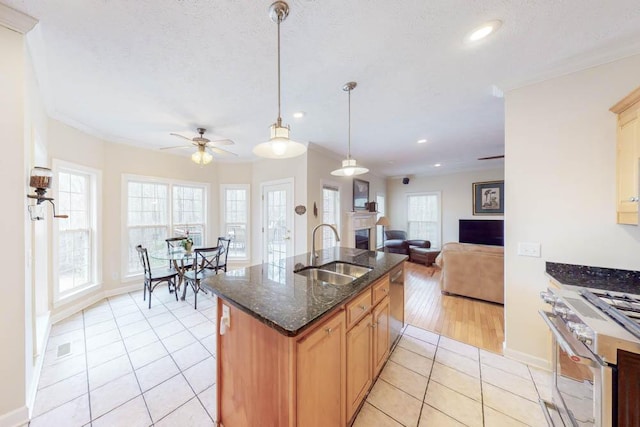 kitchen featuring ceiling fan, open floor plan, light tile patterned floors, stainless steel appliances, and a sink