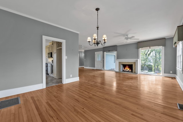 207 W Liberty St, Washington, GA 30673 - unfurnished living room featuring a warm lit fireplace, visible vents, light wood-style floors, and crown molding