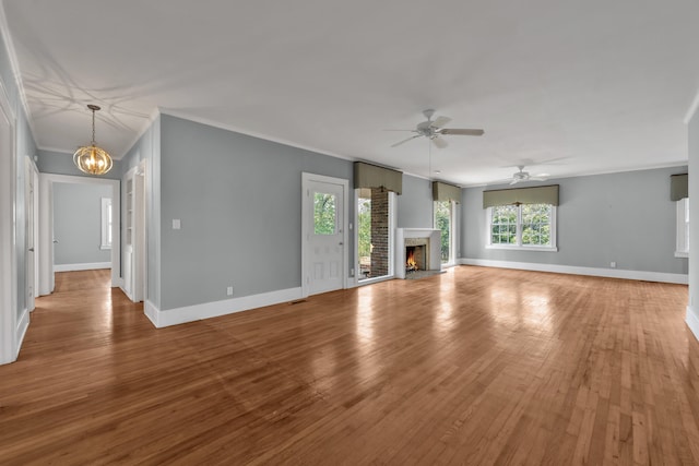 207 W Liberty St, Washington, GA 30673 - unfurnished living room with light wood-style floors, a warm lit fireplace, ornamental molding, and baseboards