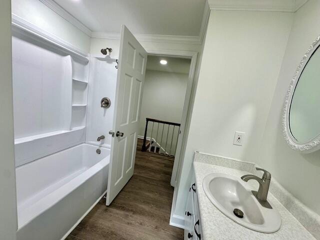 bathroom featuring hardwood / wood-style floors, vanity, bathtub / shower combination, and ornamental molding