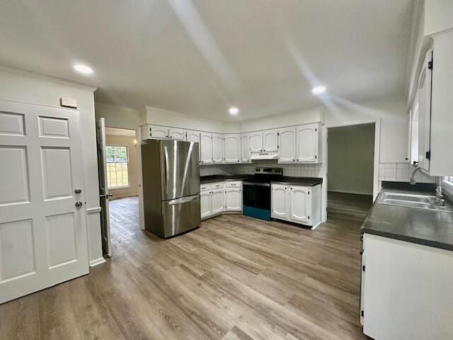 kitchen with white cabinets, backsplash, sink, and appliances with stainless steel finishes