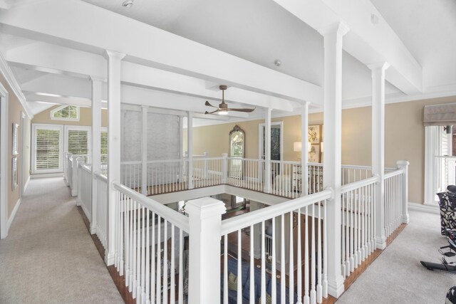 hallway featuring an upstairs landing, carpet, vaulted ceiling with beams, and decorative columns