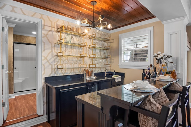 bar featuring wet bar, wood finished floors, a notable chandelier, and crown molding