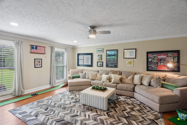 living area with wood finished floors, a ceiling fan, and ornamental molding