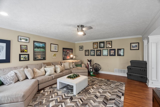 living area featuring ceiling fan, visible vents, ornamental molding, a textured ceiling, and wood finished floors